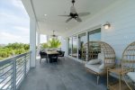 Outdoor dining balcony and cozy seating overlooking the pool and open waters.